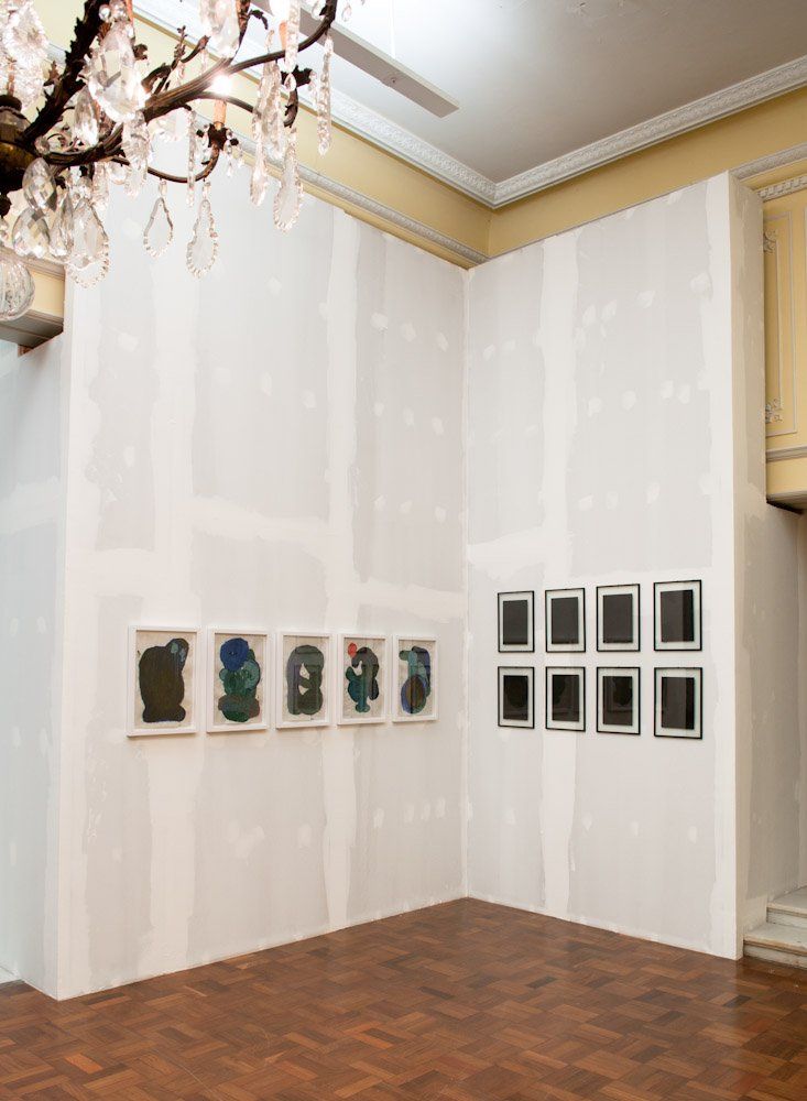 Uma sala com muitos quadros na parede e um lustre pendurado no teto.