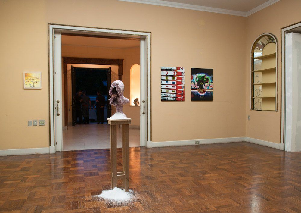 Uma sala com piso de madeira e uma estátua no meio.