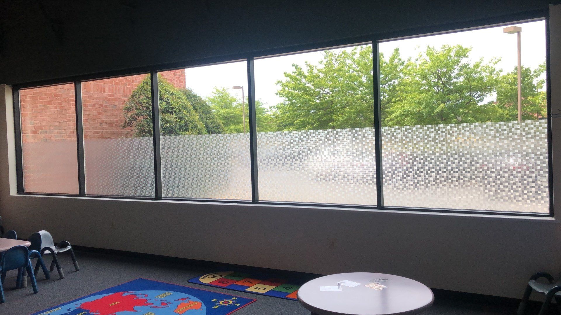 A room with a lot of windows and a rug on the floor.