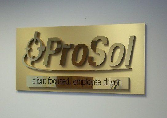 A gold sign that says prosol client focused employee driven