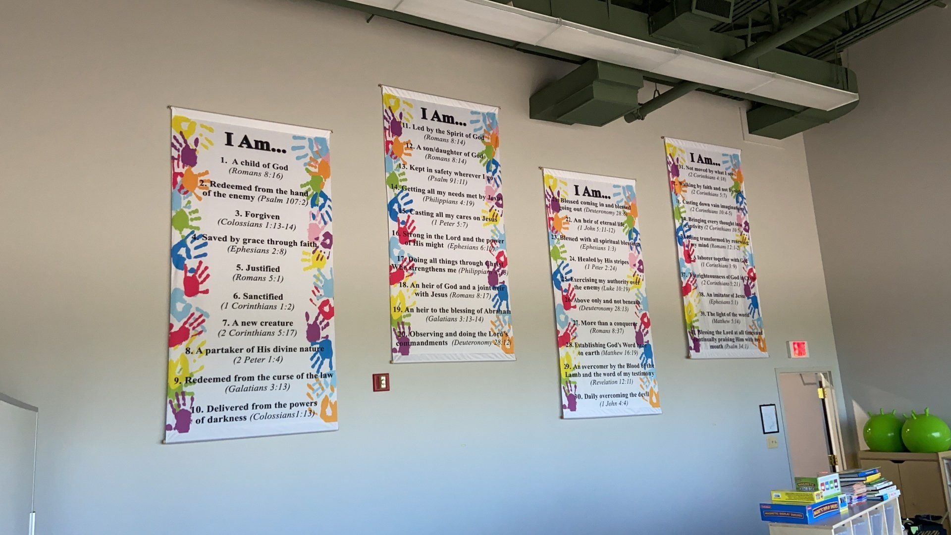 Three posters are hanging on a wall in a classroom.