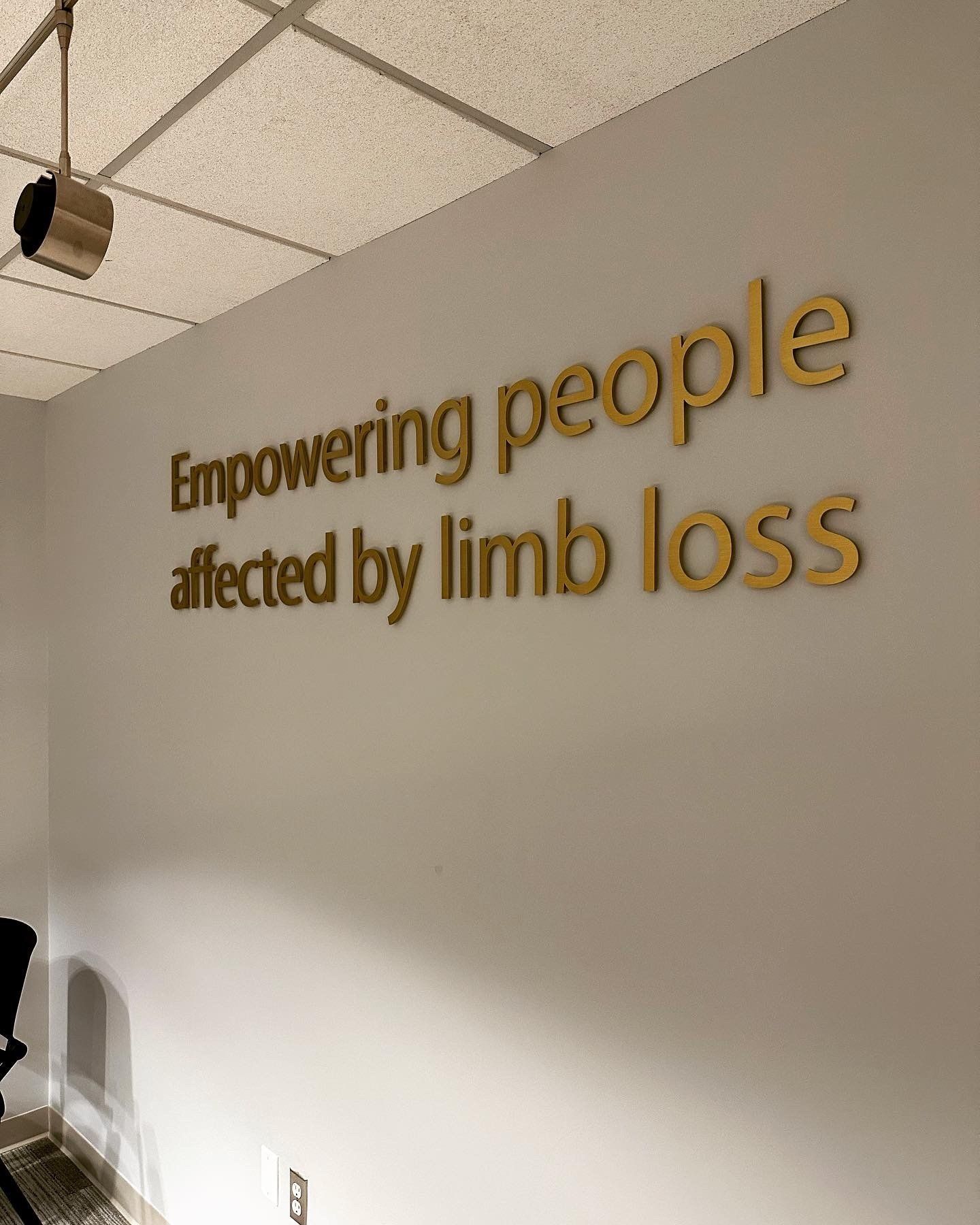 A sign on a wall that says empowering people affected by limb loss