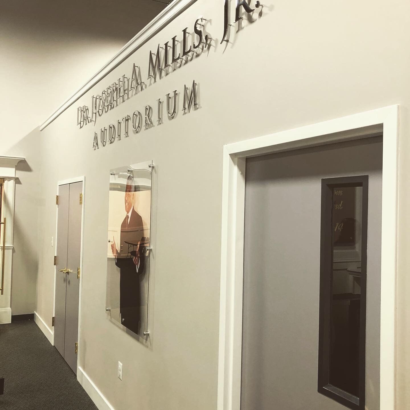 A hallway with a sign that says mills auditorium