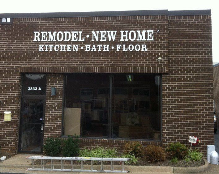 A brick building with a sign that says remodel new home kitchen bath floor