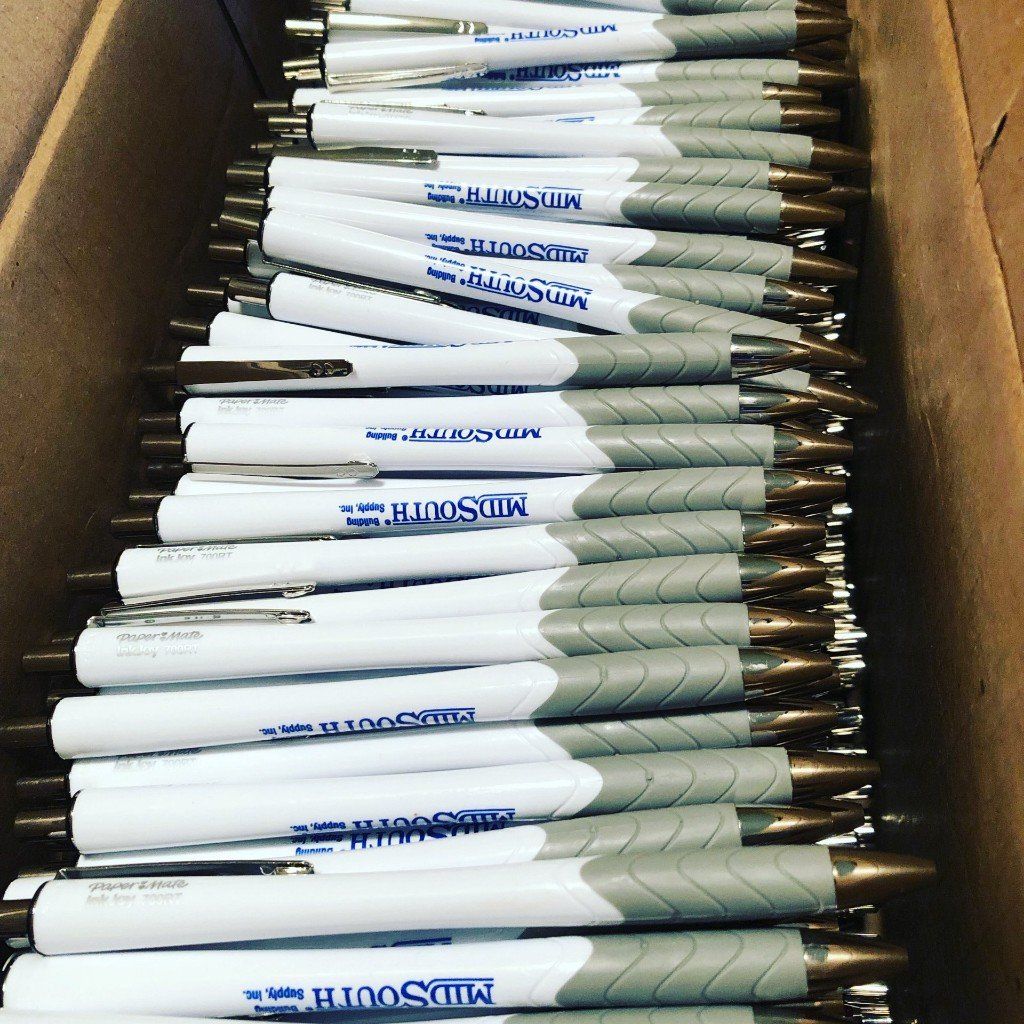 A box filled with a bunch of pens that say ' johnson ' on them