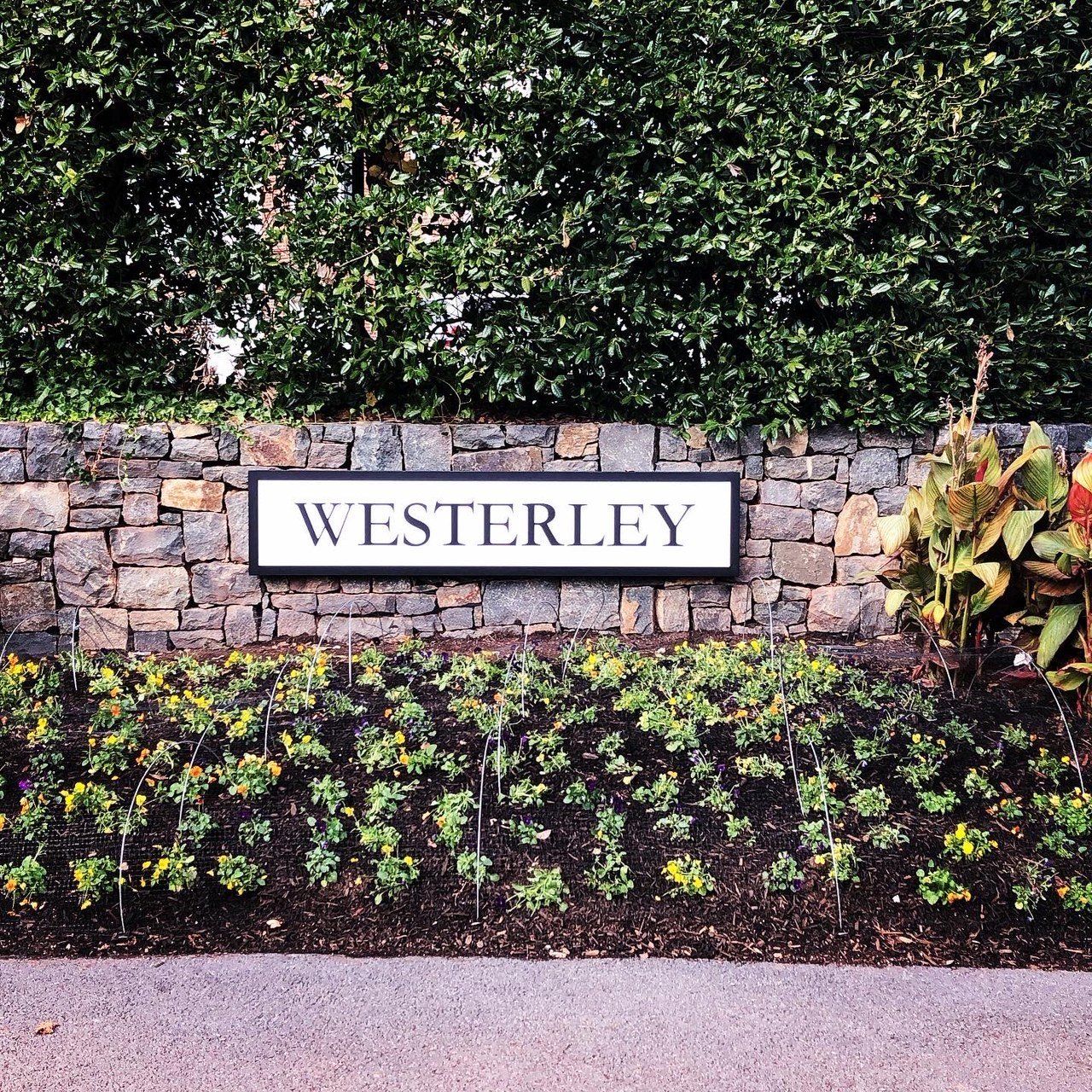 A stone wall with a sign that says ' westerley ' on it