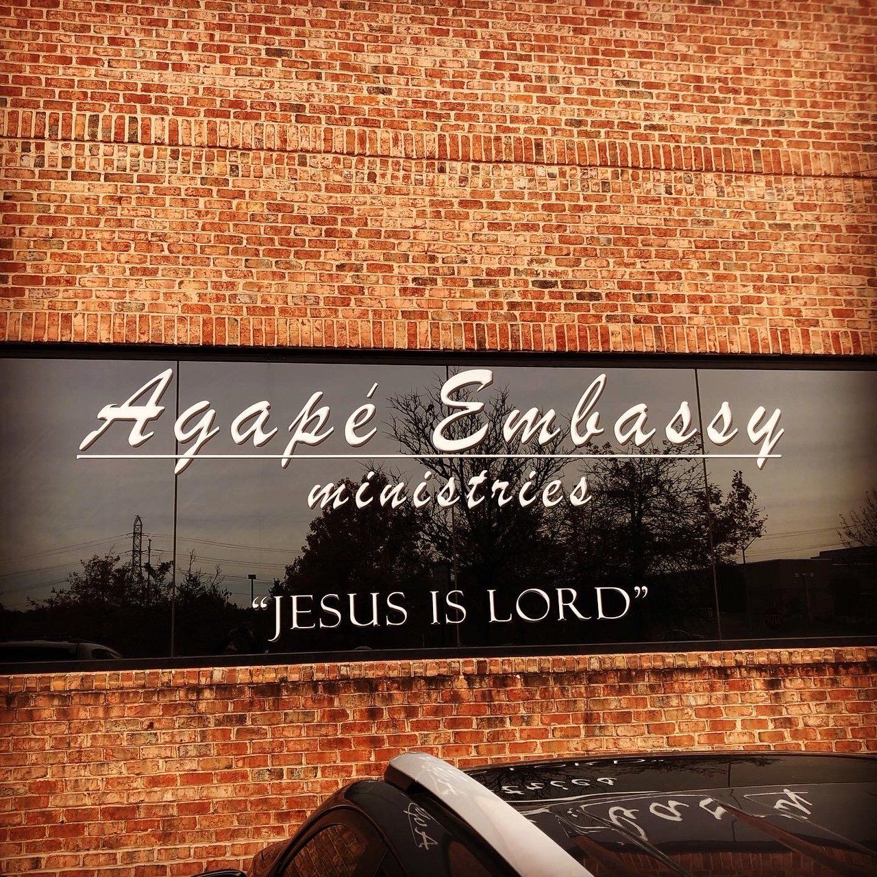 A brick building with a sign that says agape embassy ministries