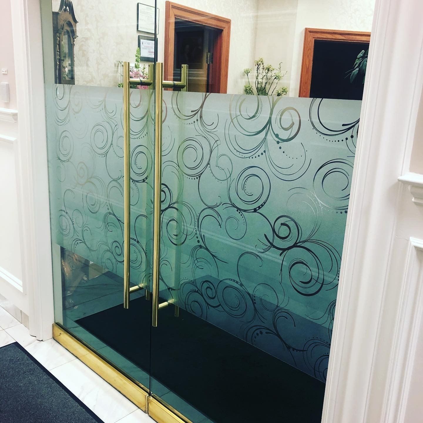 A glass door with a swirl design on it