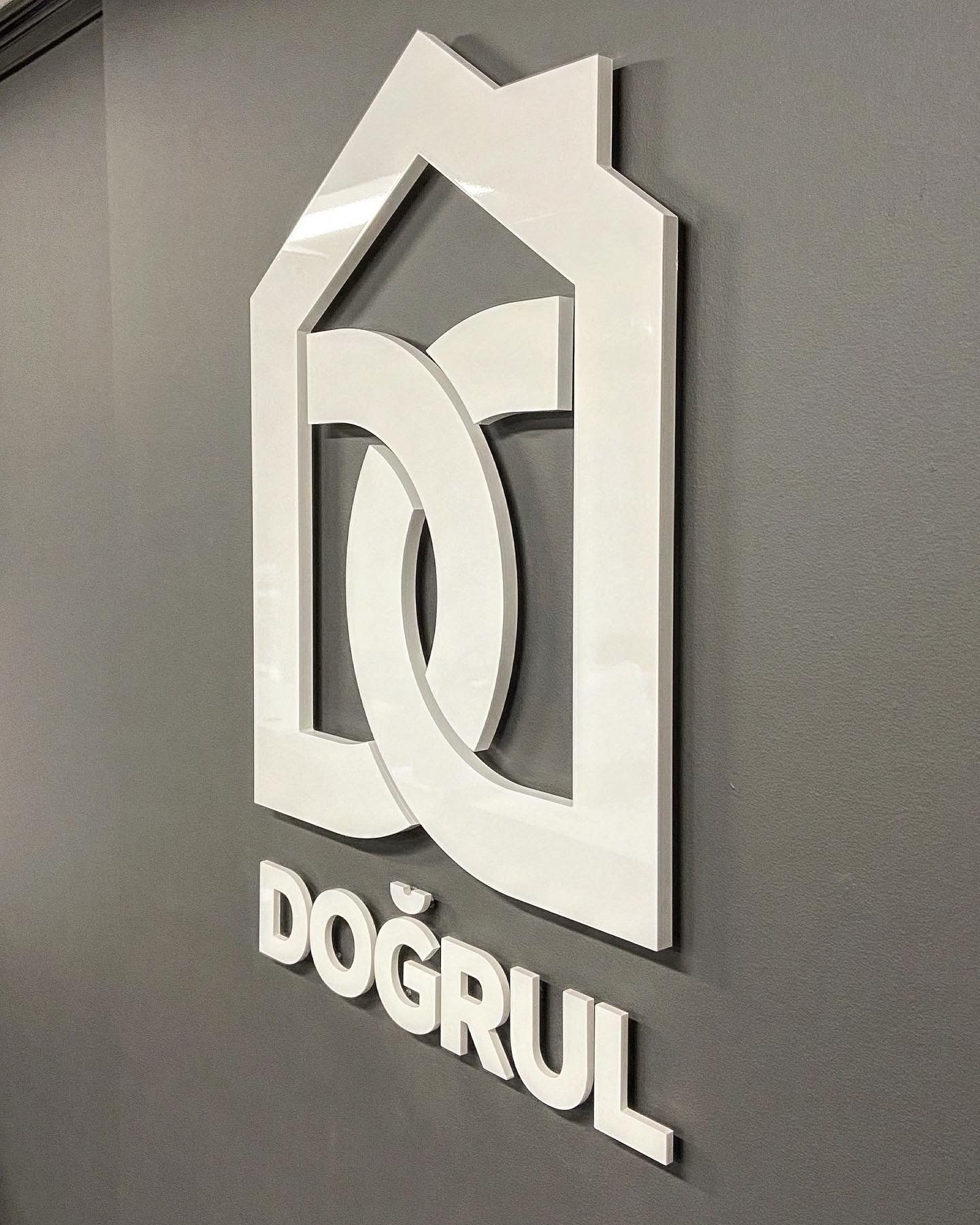A white dogrul logo is on a gray wall.