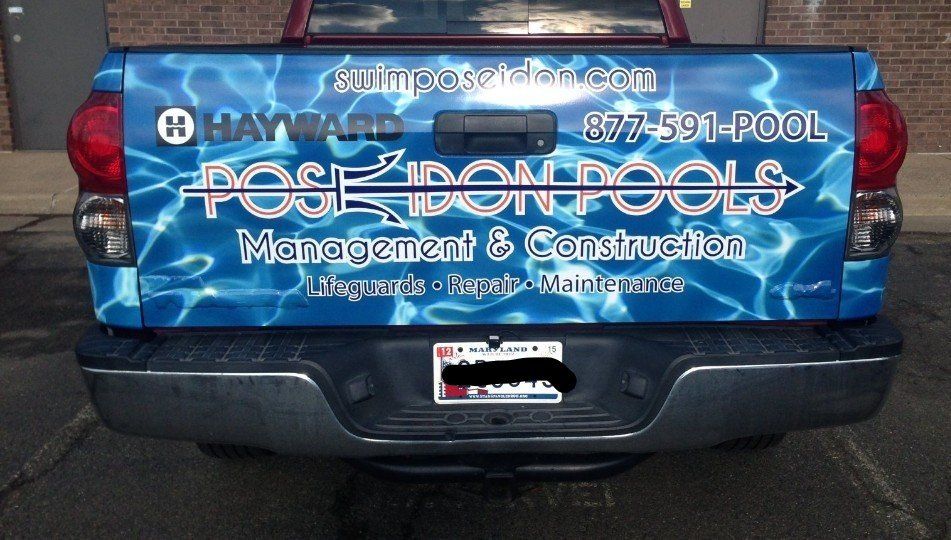 A truck with a sticker on the back that says poseidon pools management & construction