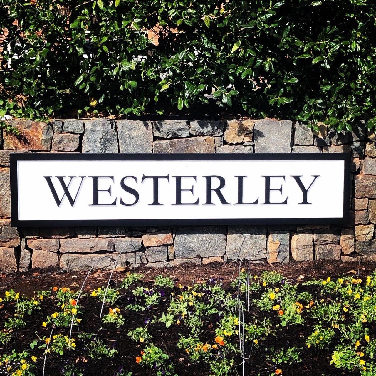 A stone wall with a sign that says ' westerley ' on it