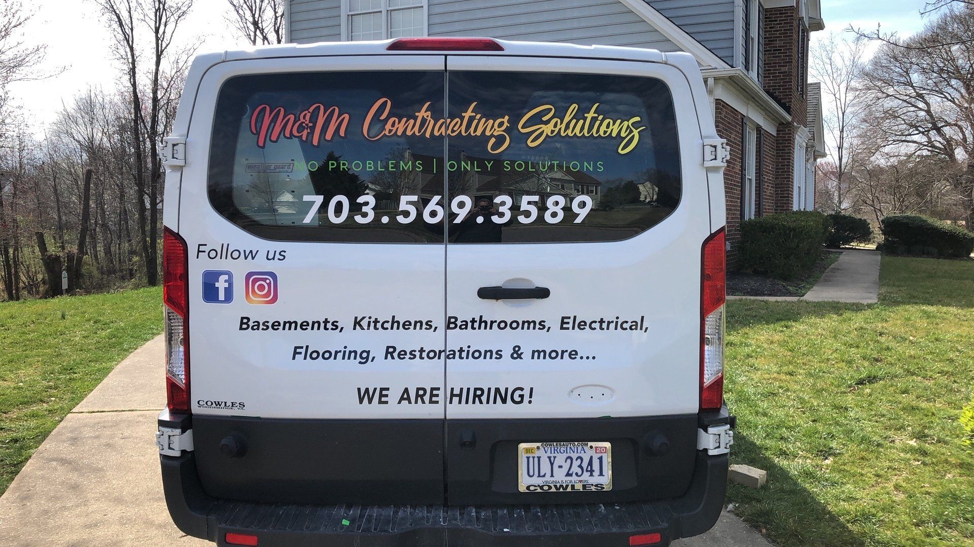 A white van is parked in front of a house.