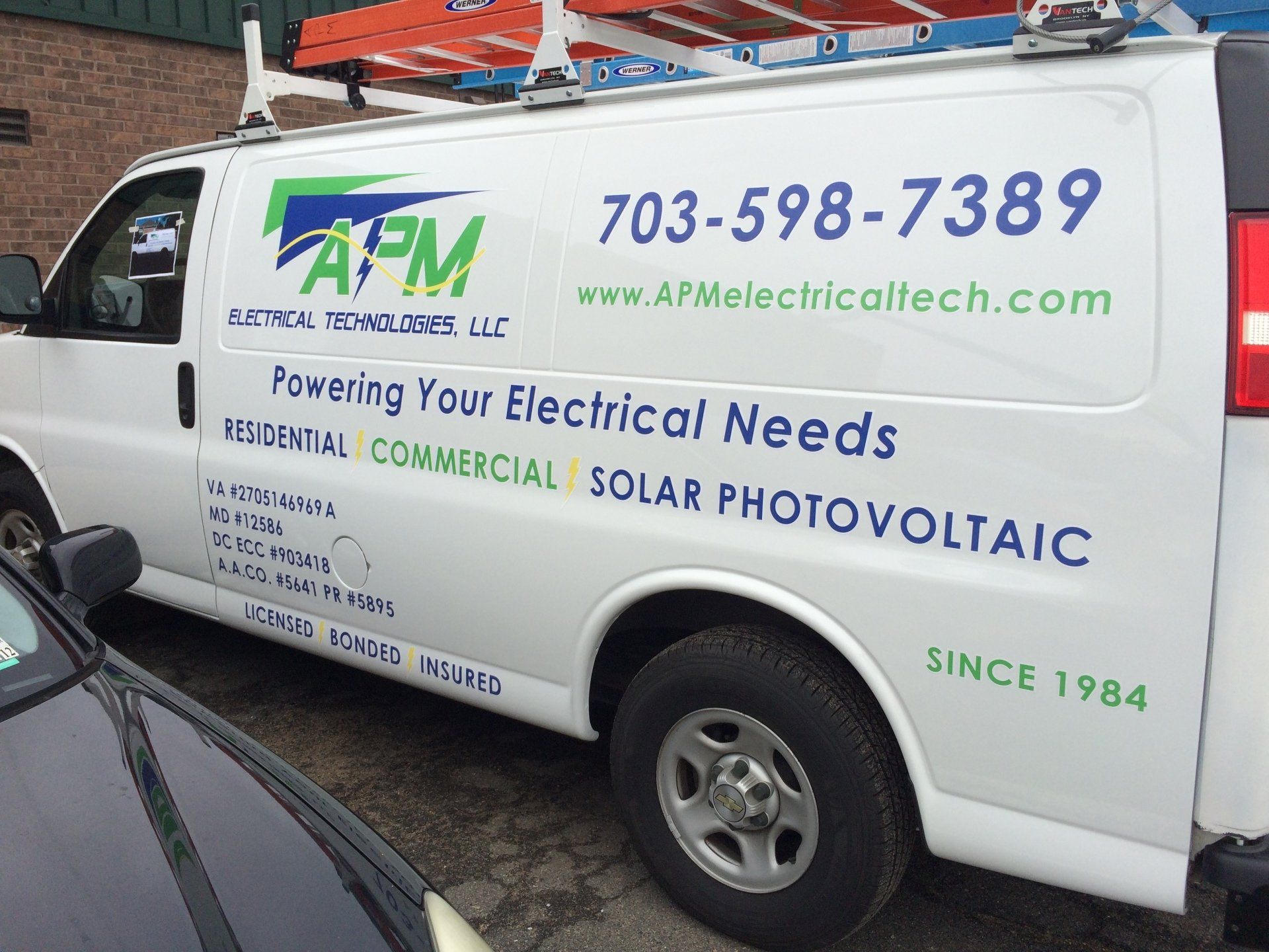 A white van that says apm powering your electrical needs