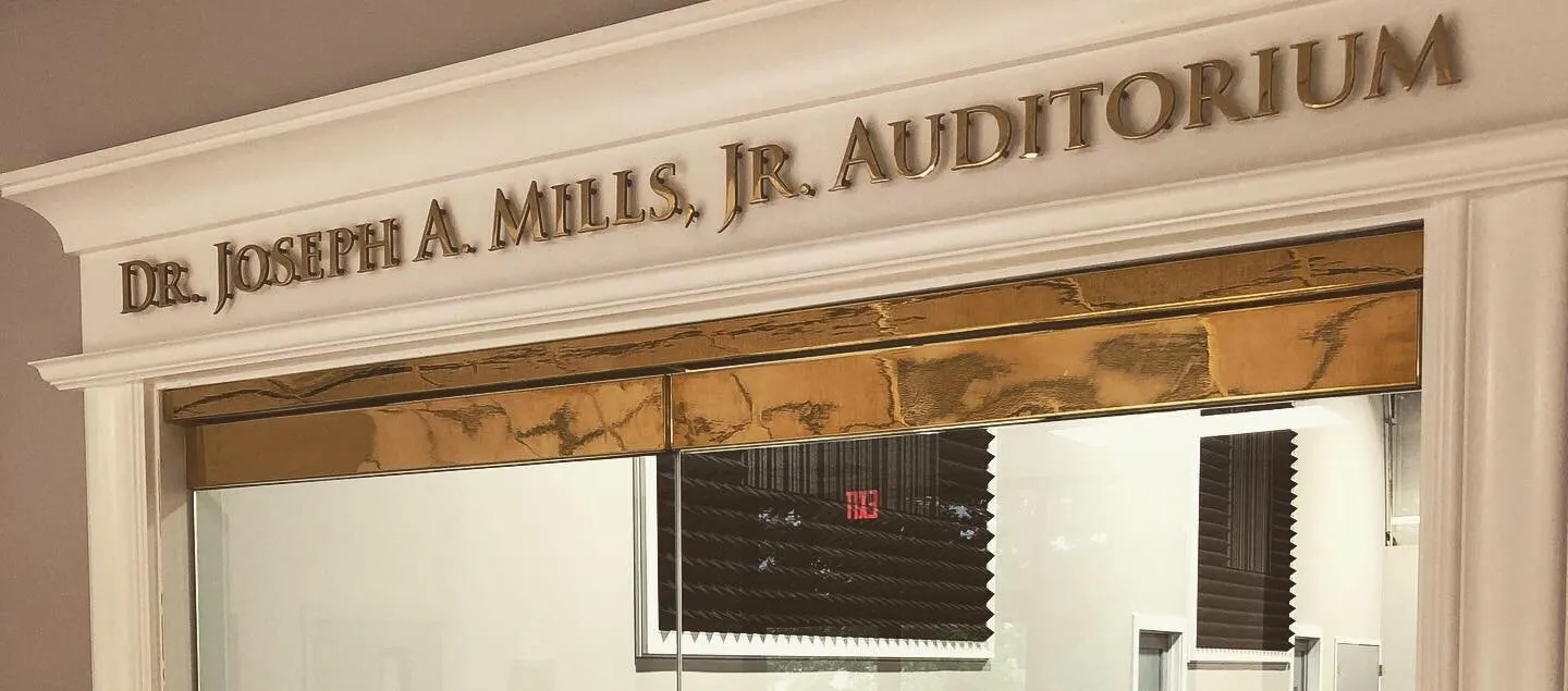 A sign for dr. joseph a. mills jr. auditorium is above a doorway