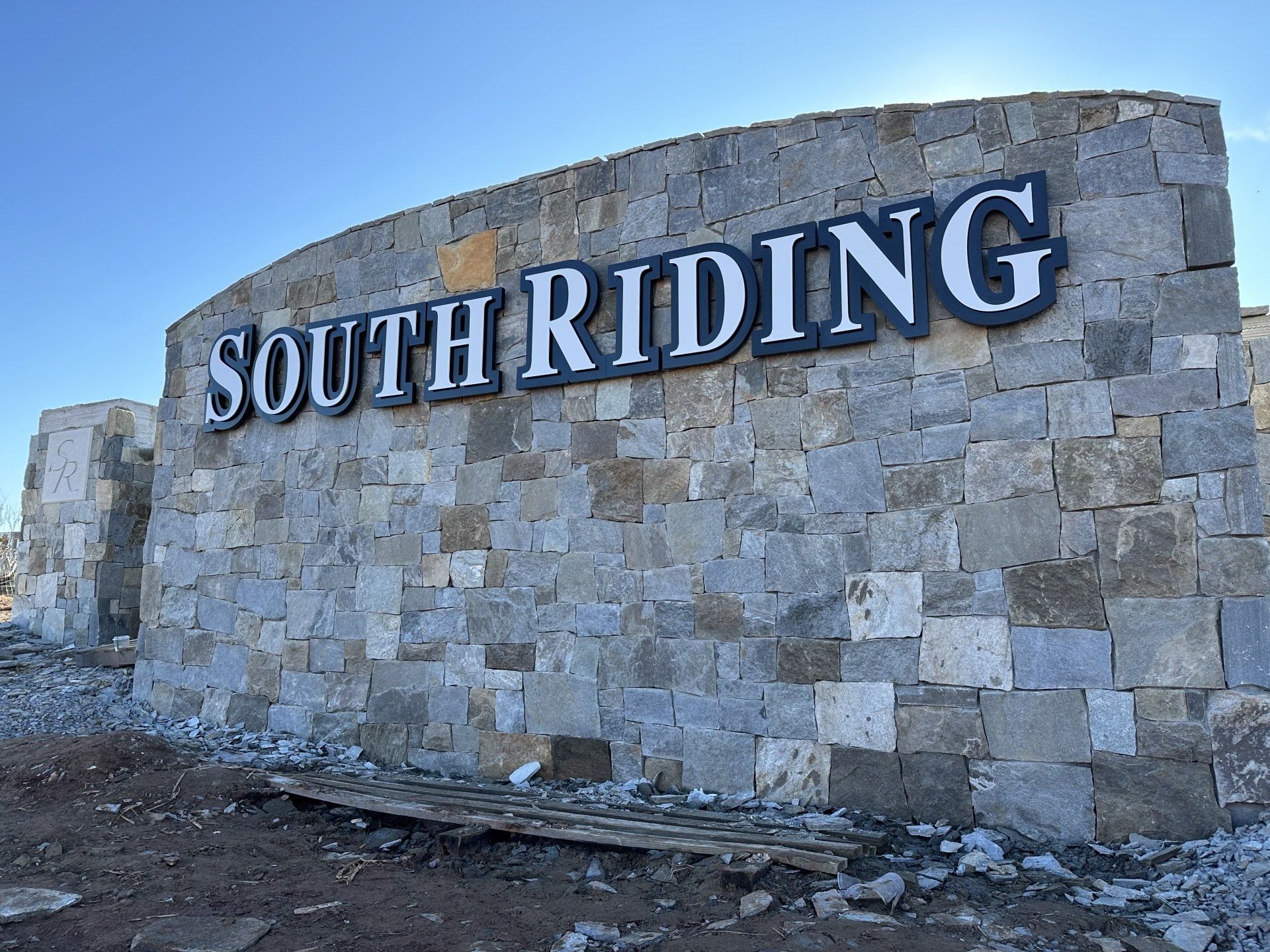 A large stone wall with the words south riding on it