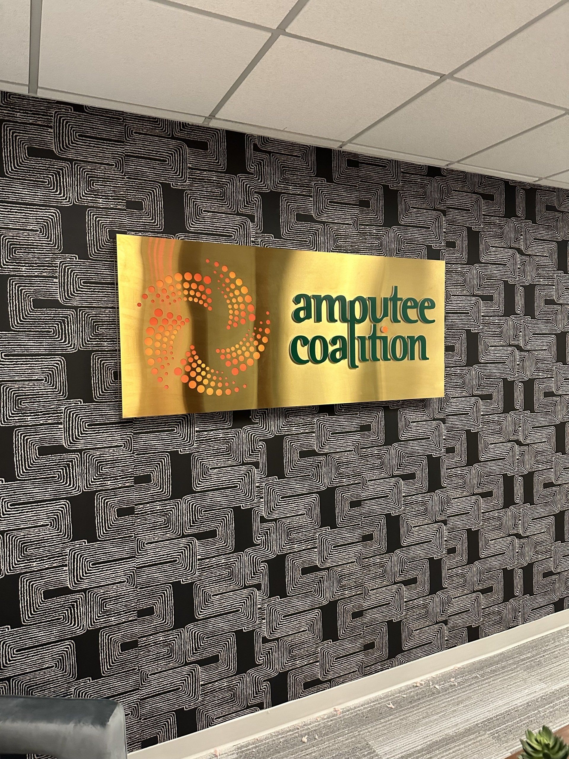 A sign on a wall that says amputee coalition