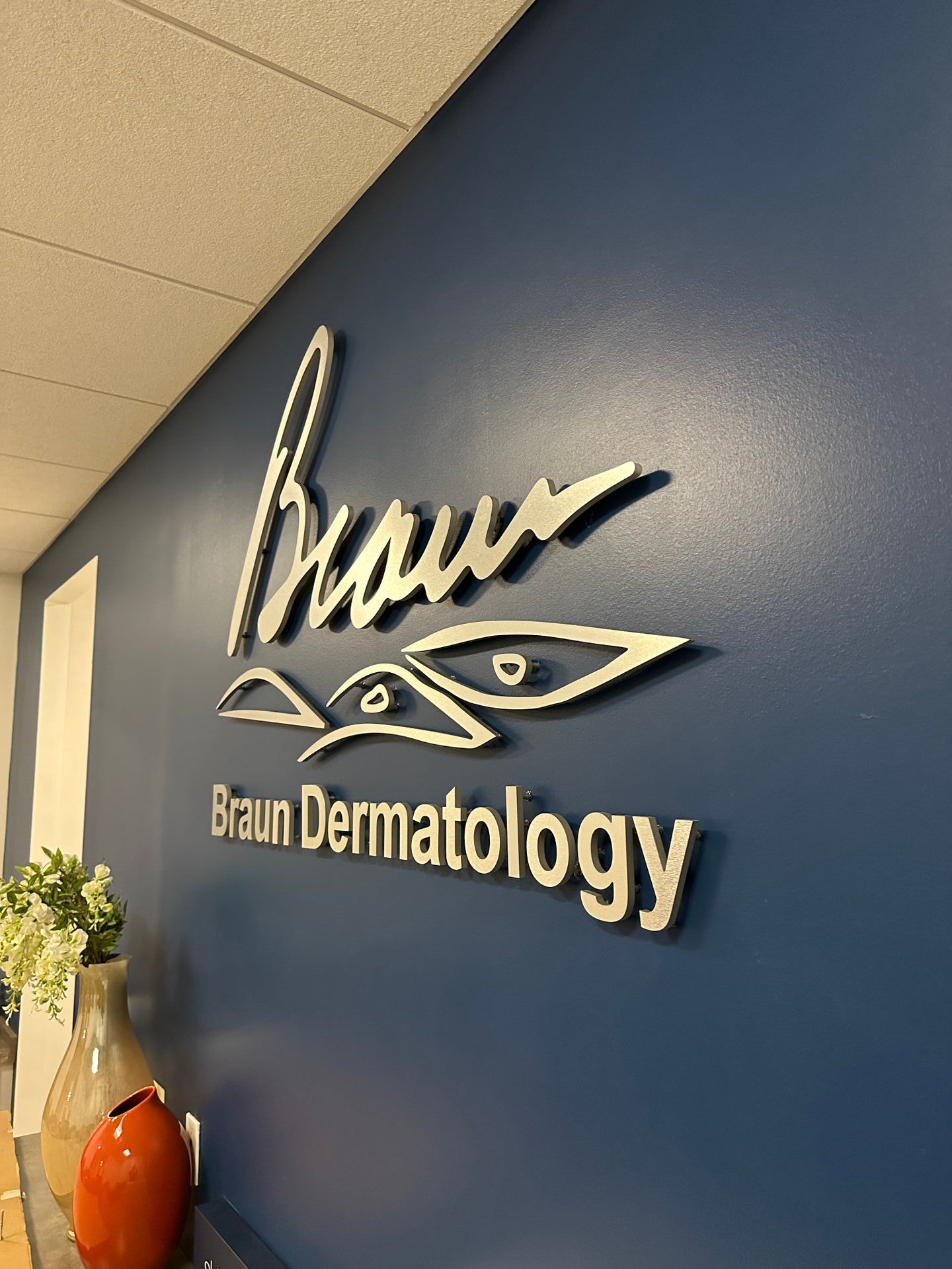 A blue wall with braun dermatology written on it