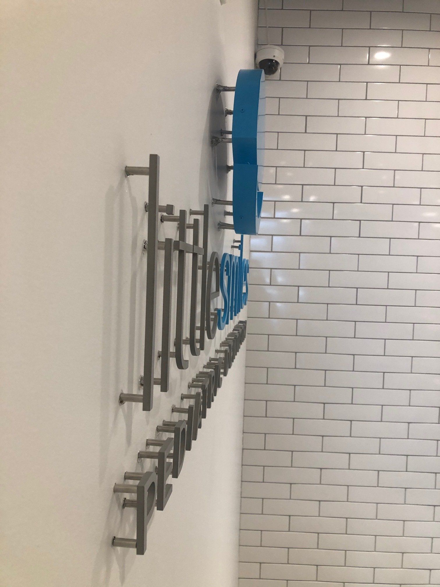 A white brick wall with a blue sign on it