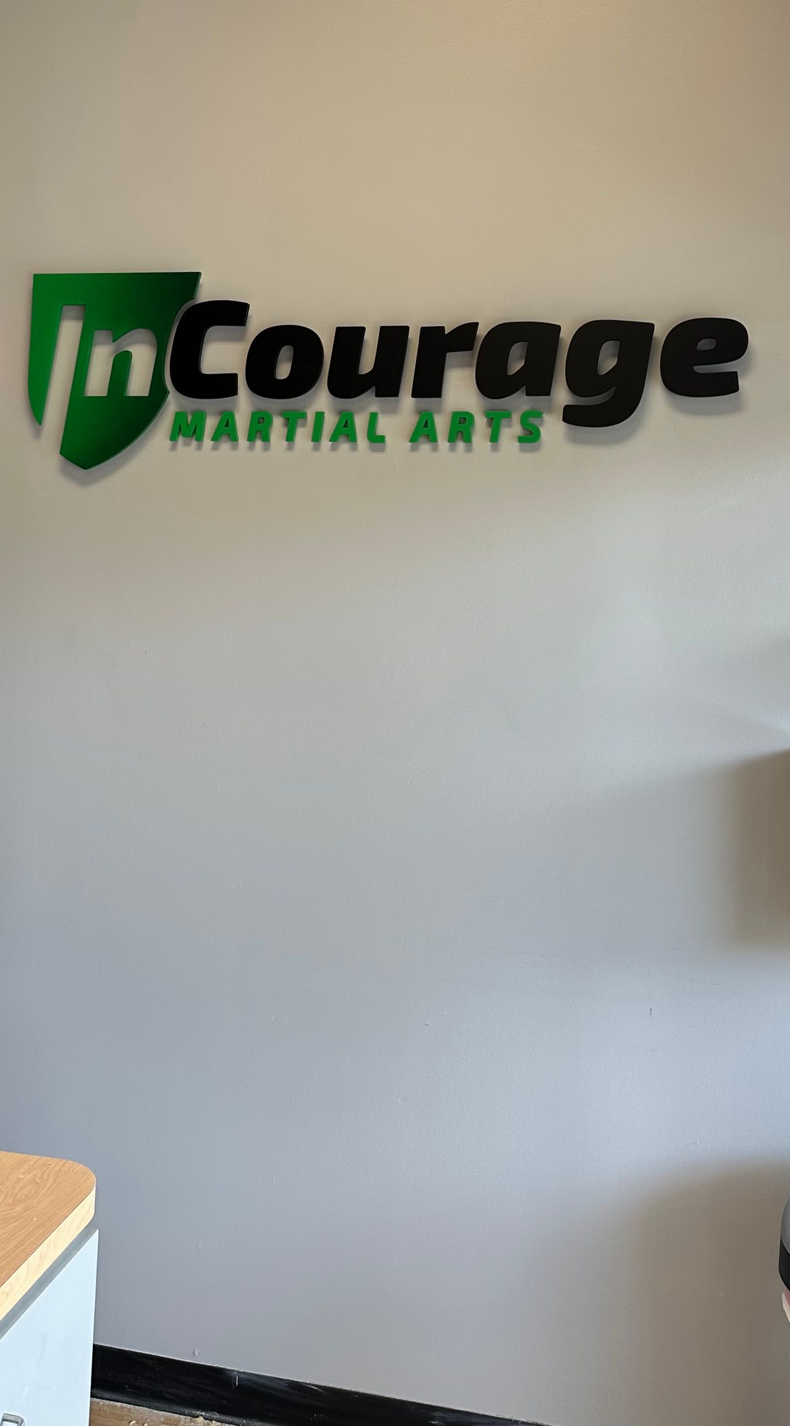 A sign on a wall that says `` in courage martial arts ''.