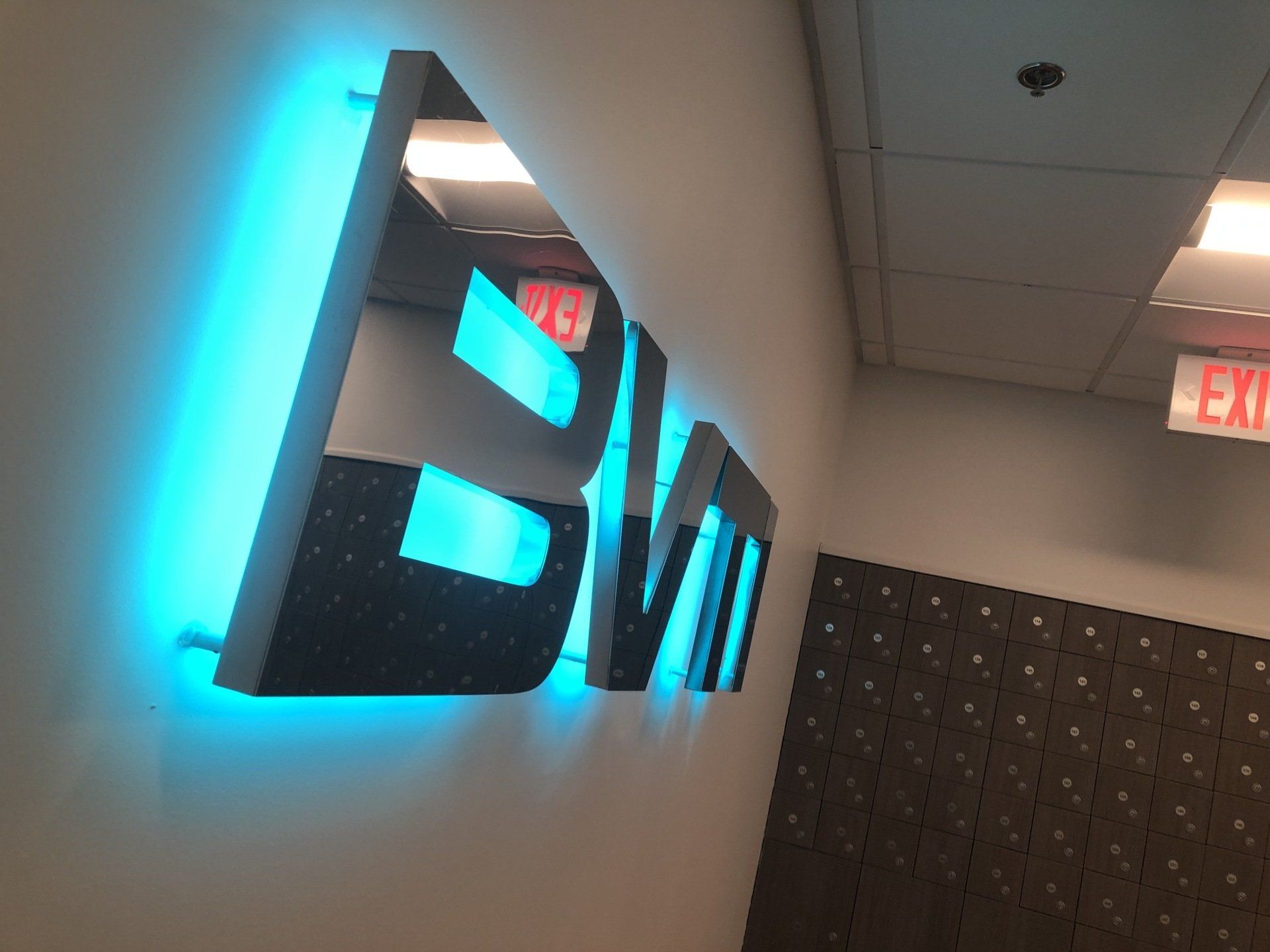 A sign that says bm is lit up with blue lights