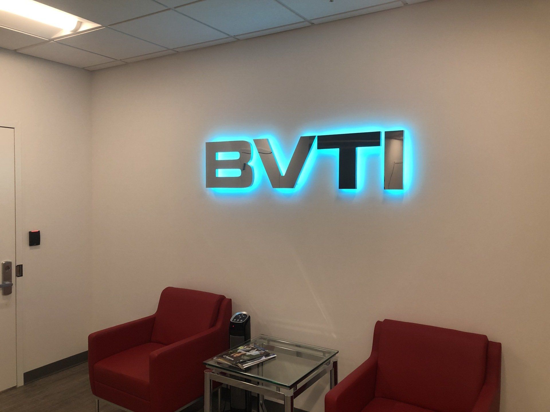A room with two red chairs and a sign that says bvti