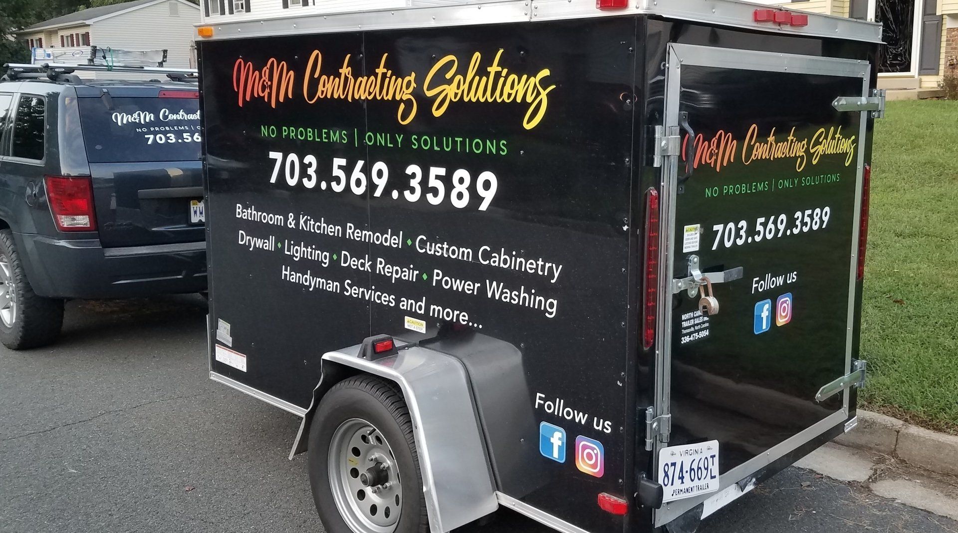 A trailer with a phone number on it is parked on the side of the road.