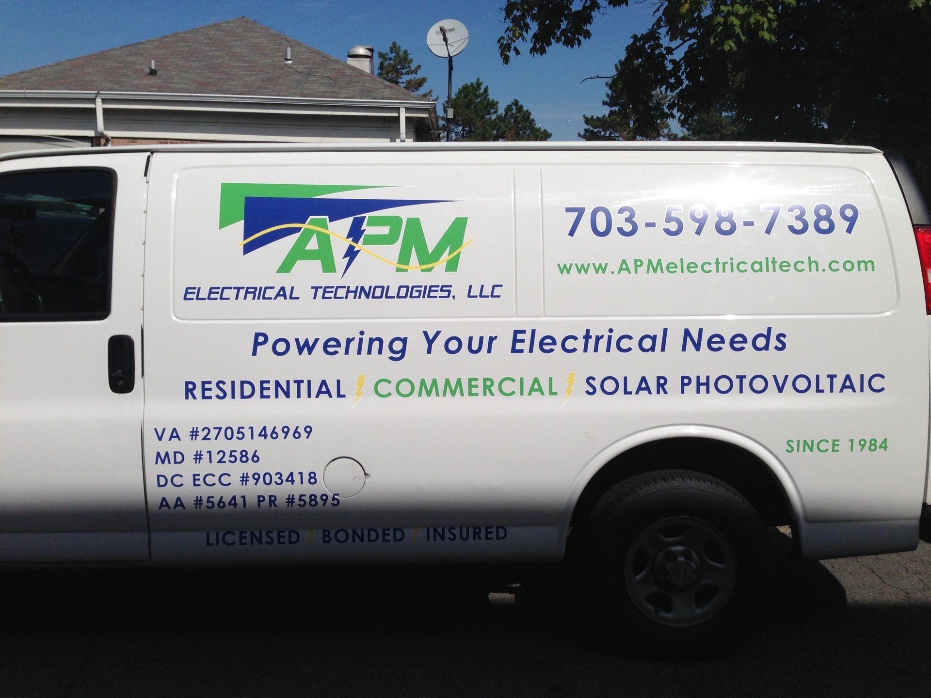 A white van that says apm powering your electrical needs