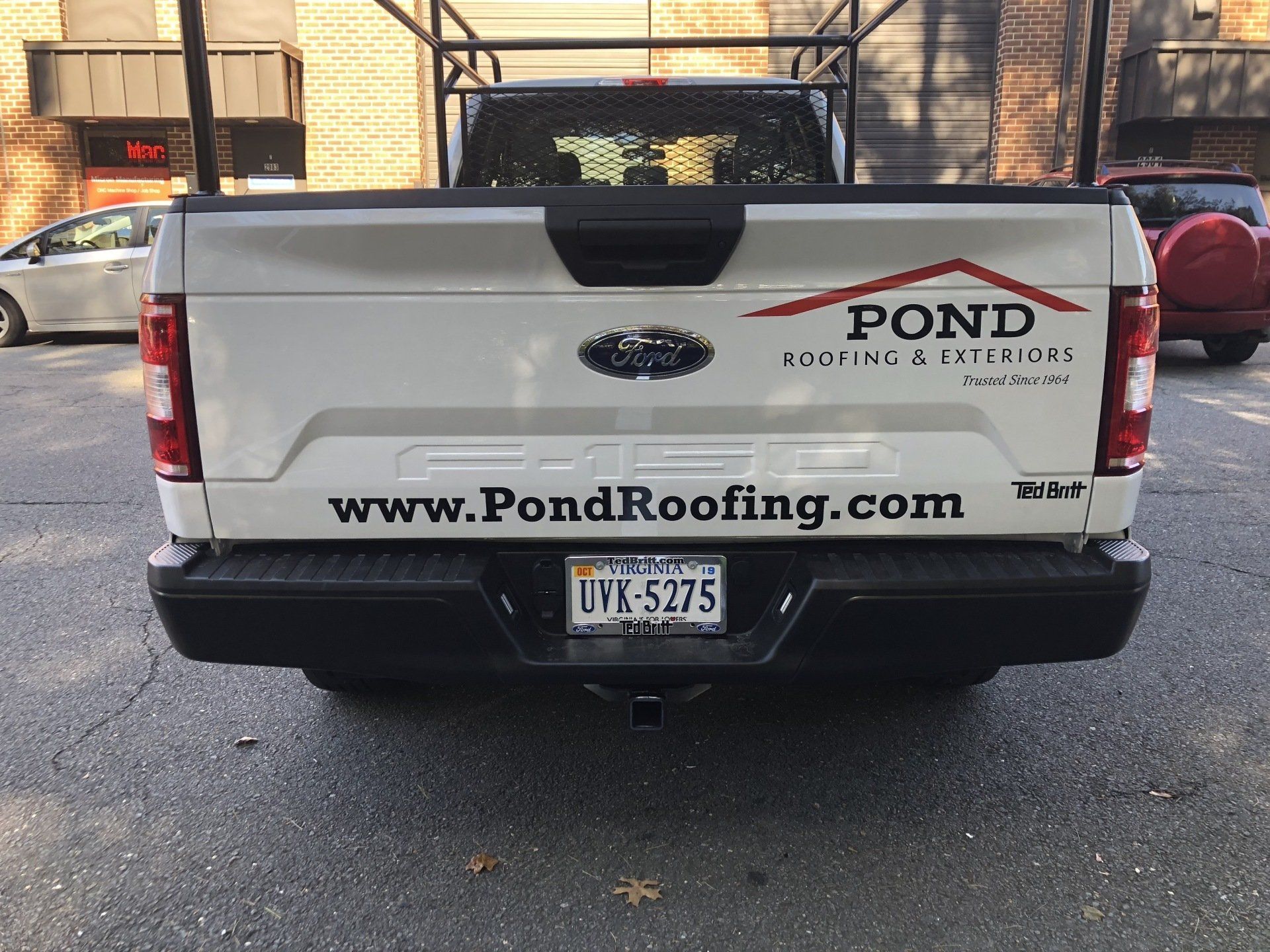 A white truck with a roofing company written on it