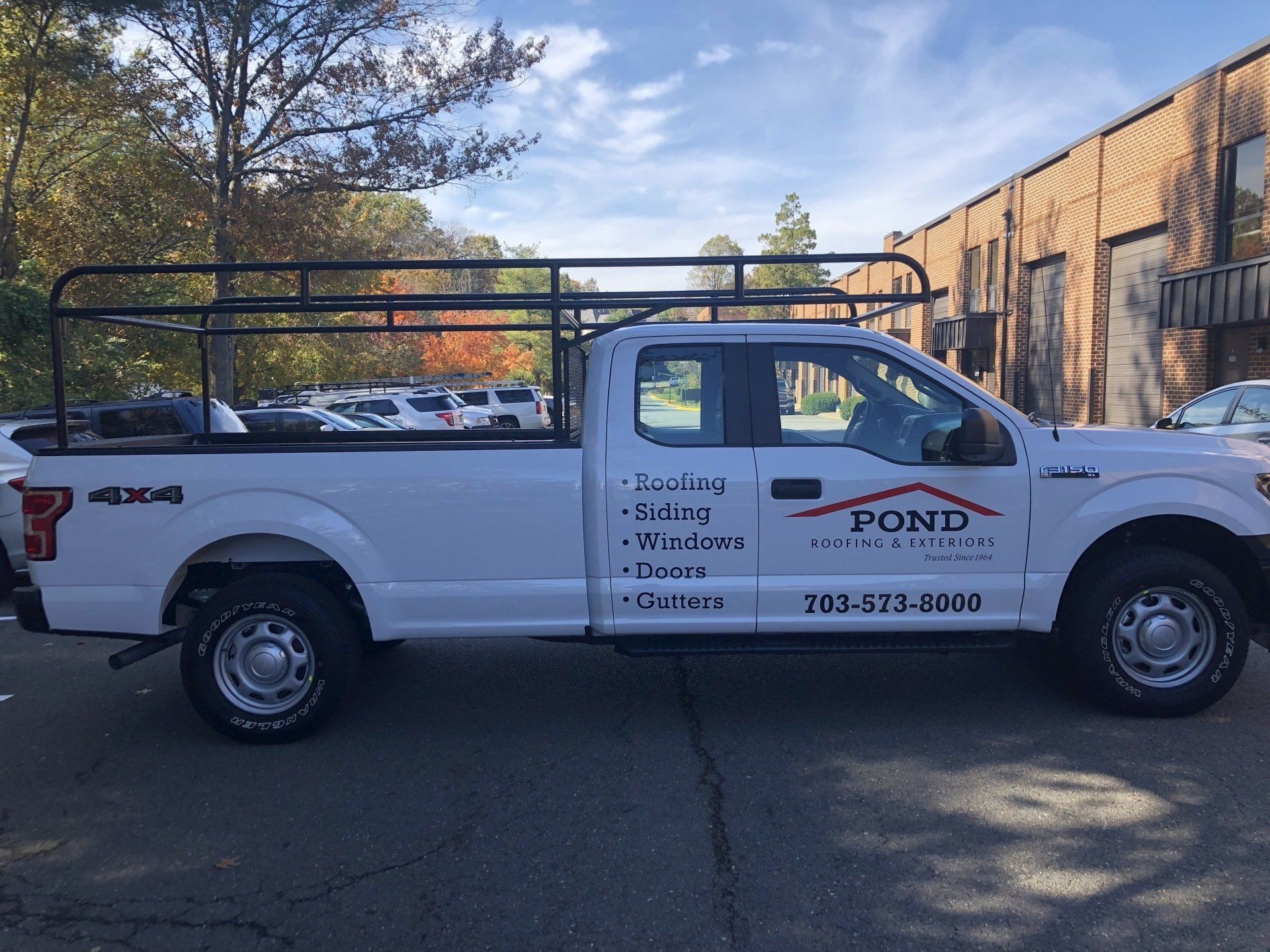A white truck with the word pond on the side is parked in front of a building.