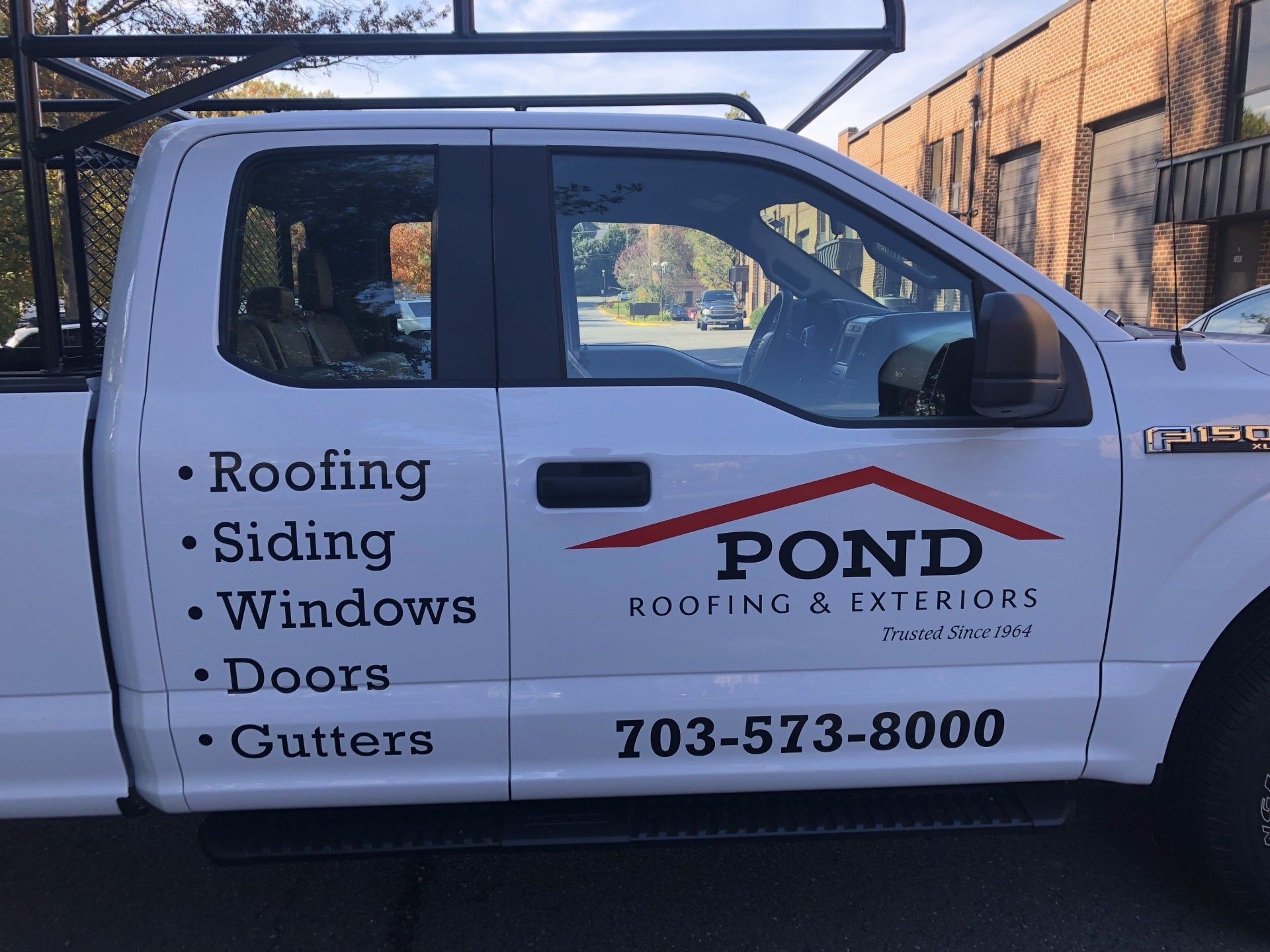 A white truck for pond roofing and exteriors