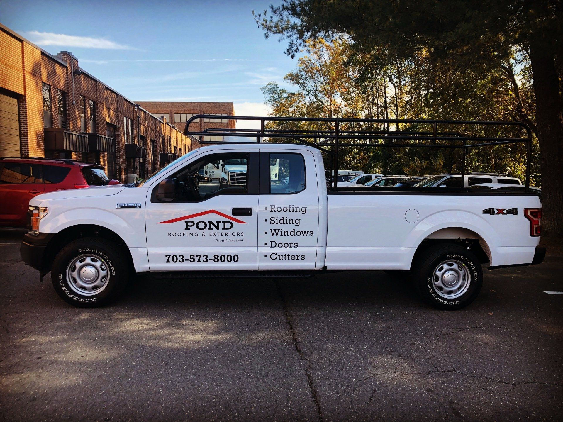 A white truck with the word pond on the side is parked in front of a building.