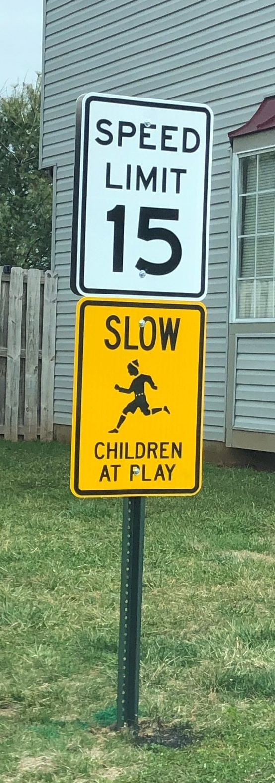 A speed limit sign that says 15 and slow children at play