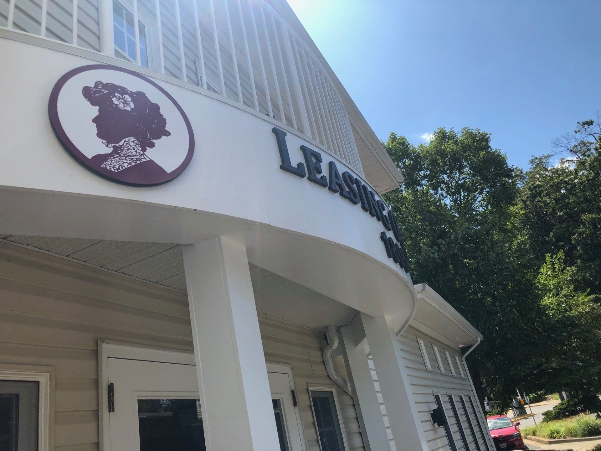 A white building with a sign that says leasing on it