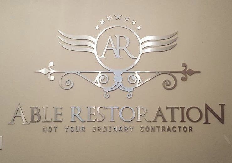 The logo for able restoration is on a wall