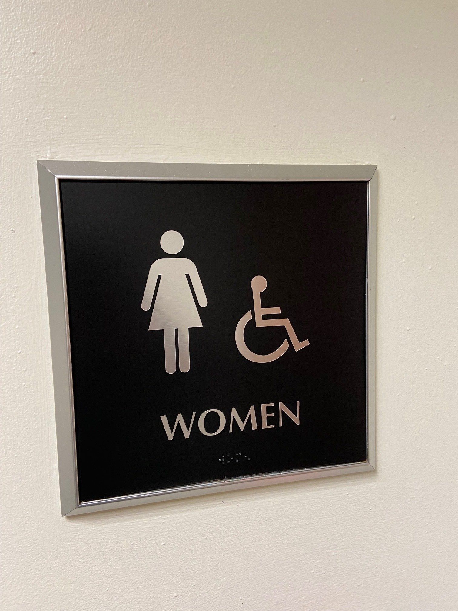 A sign for a women 's bathroom with a handicapped person.