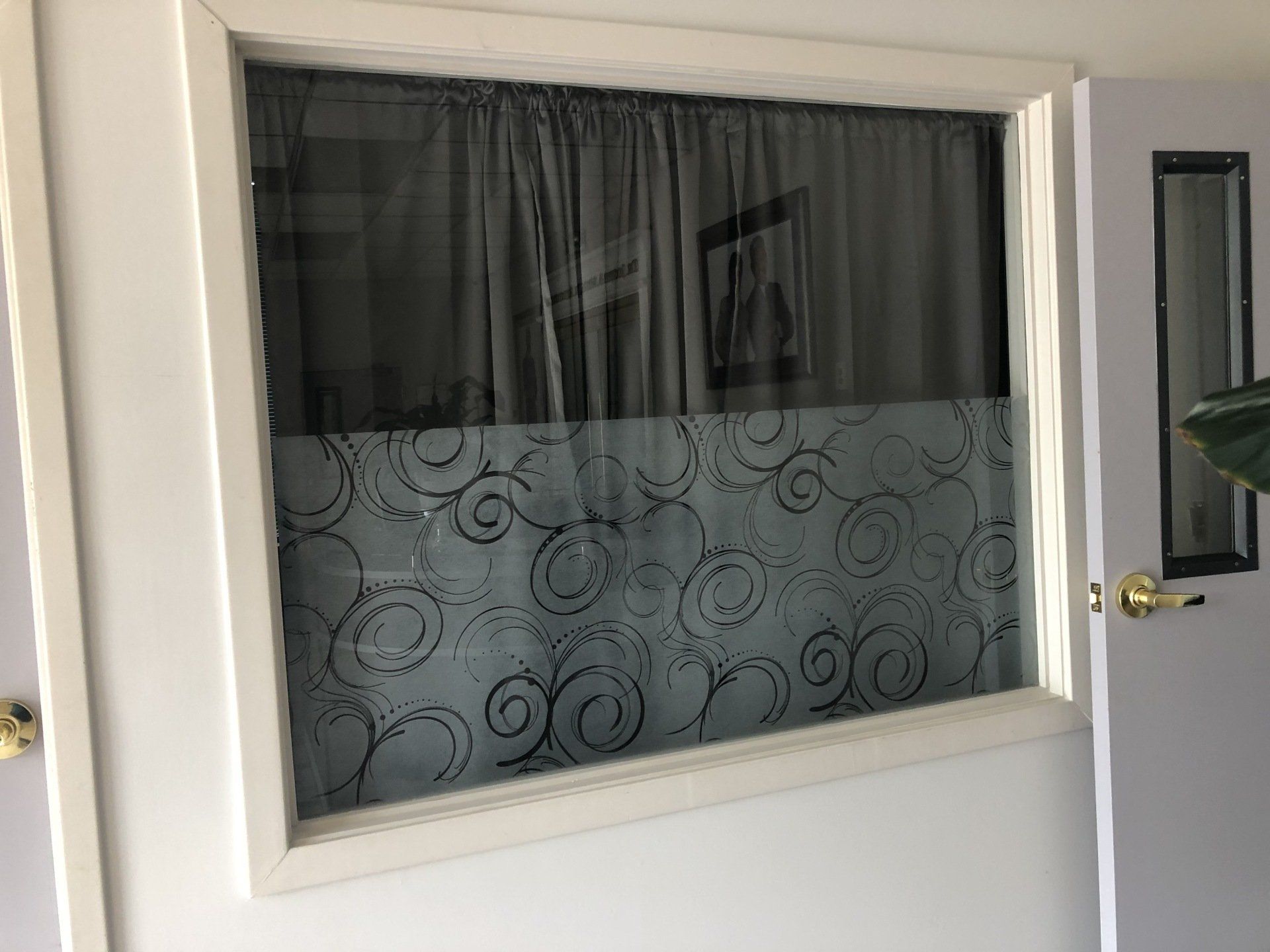 A door with a window and a curtain on it.