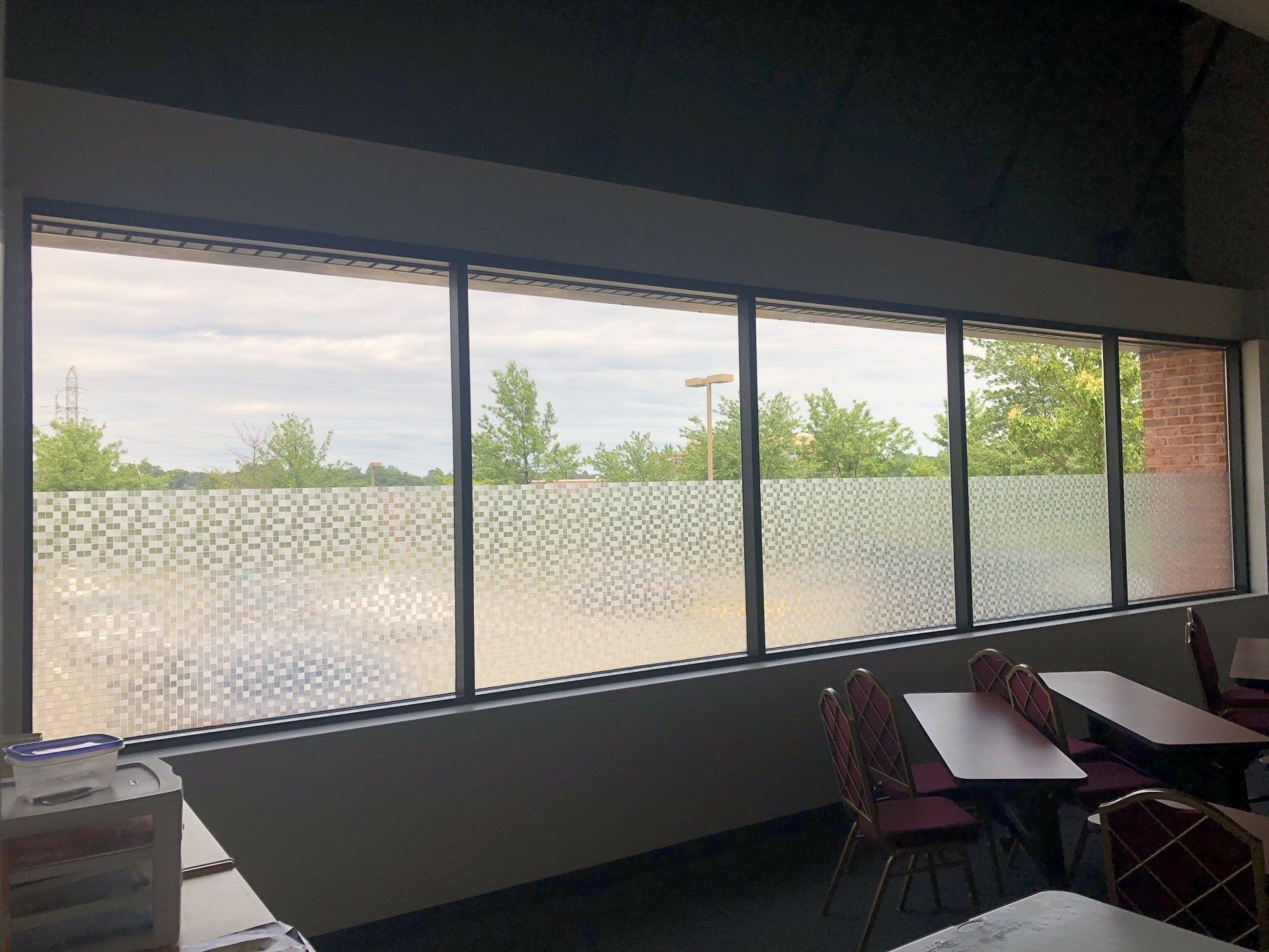 A room with a lot of windows and tables and chairs.