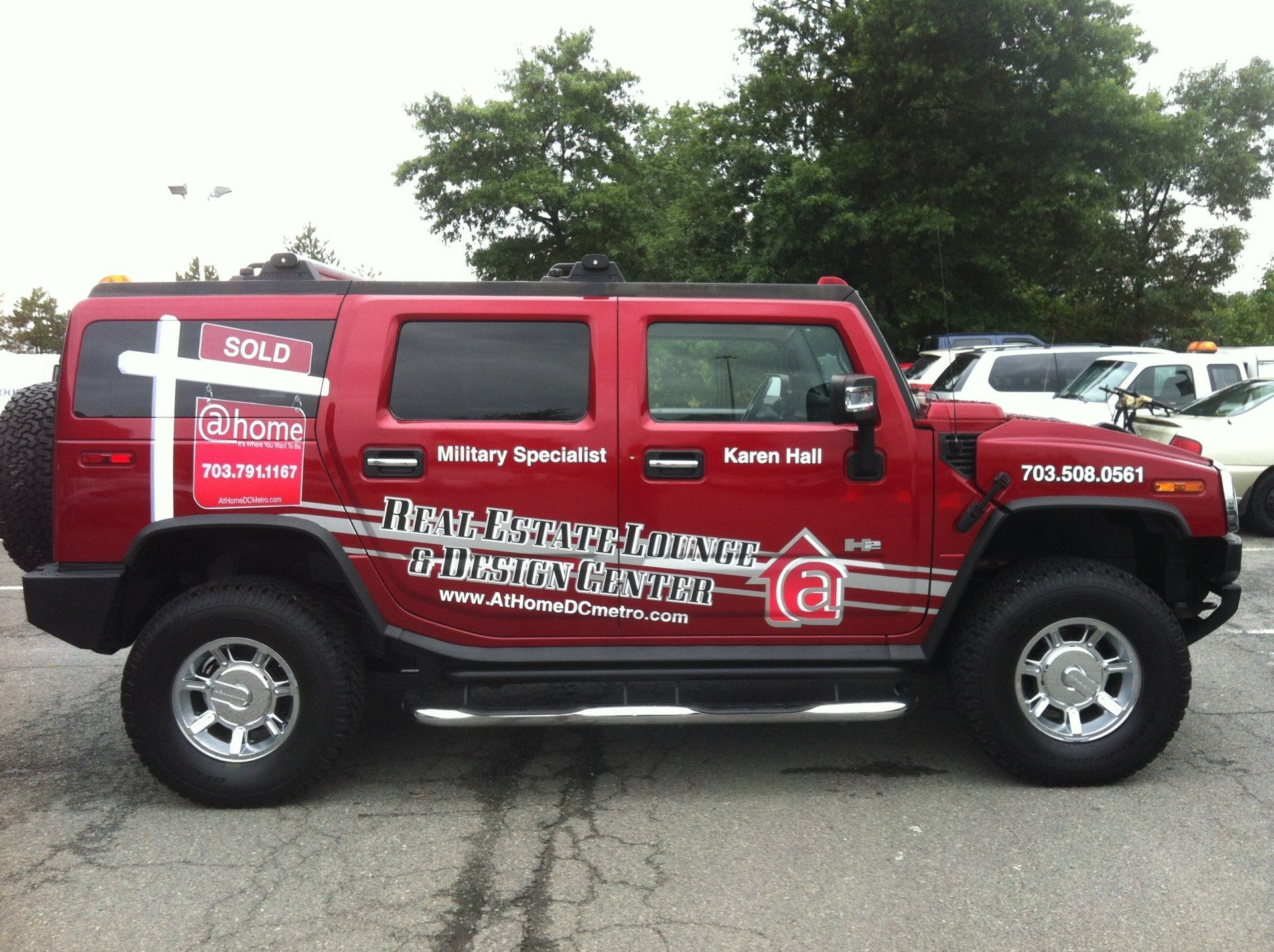 A red hummer is parked in a parking lot