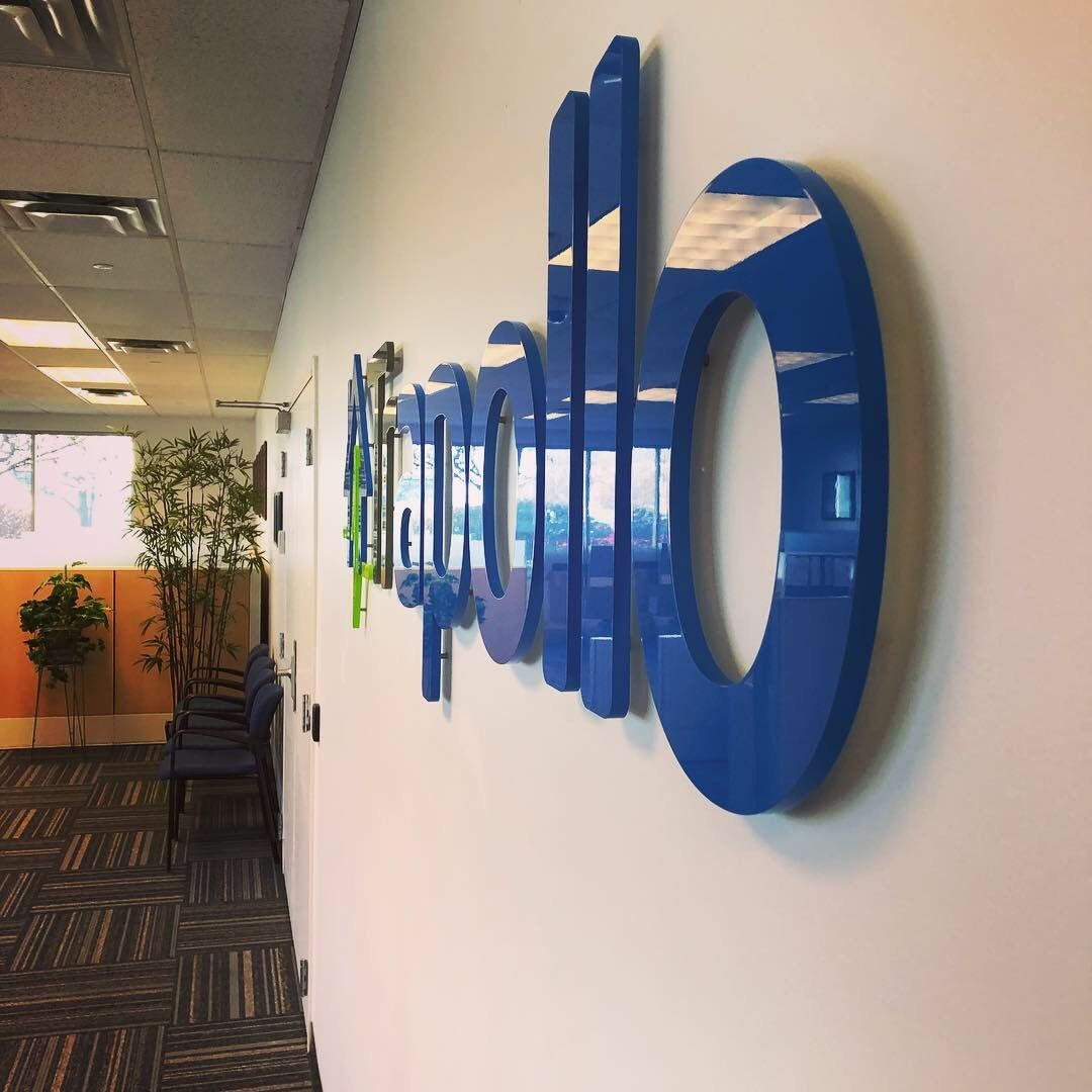 A blue sign on a wall that says apollo