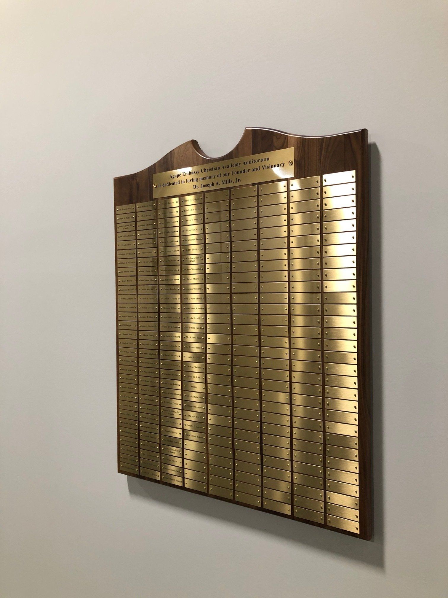 A gold ruler is hanging on a white wall