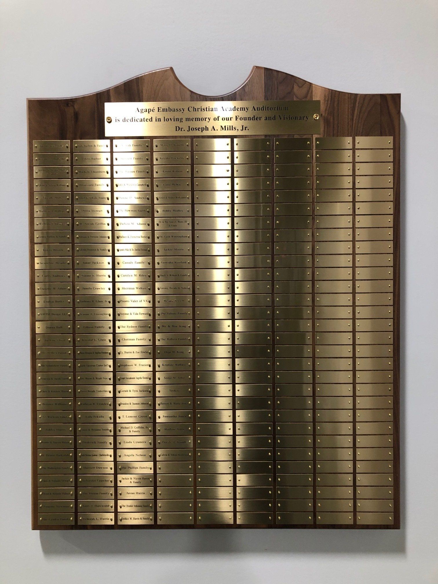 A wooden plaque with brass plaques on it