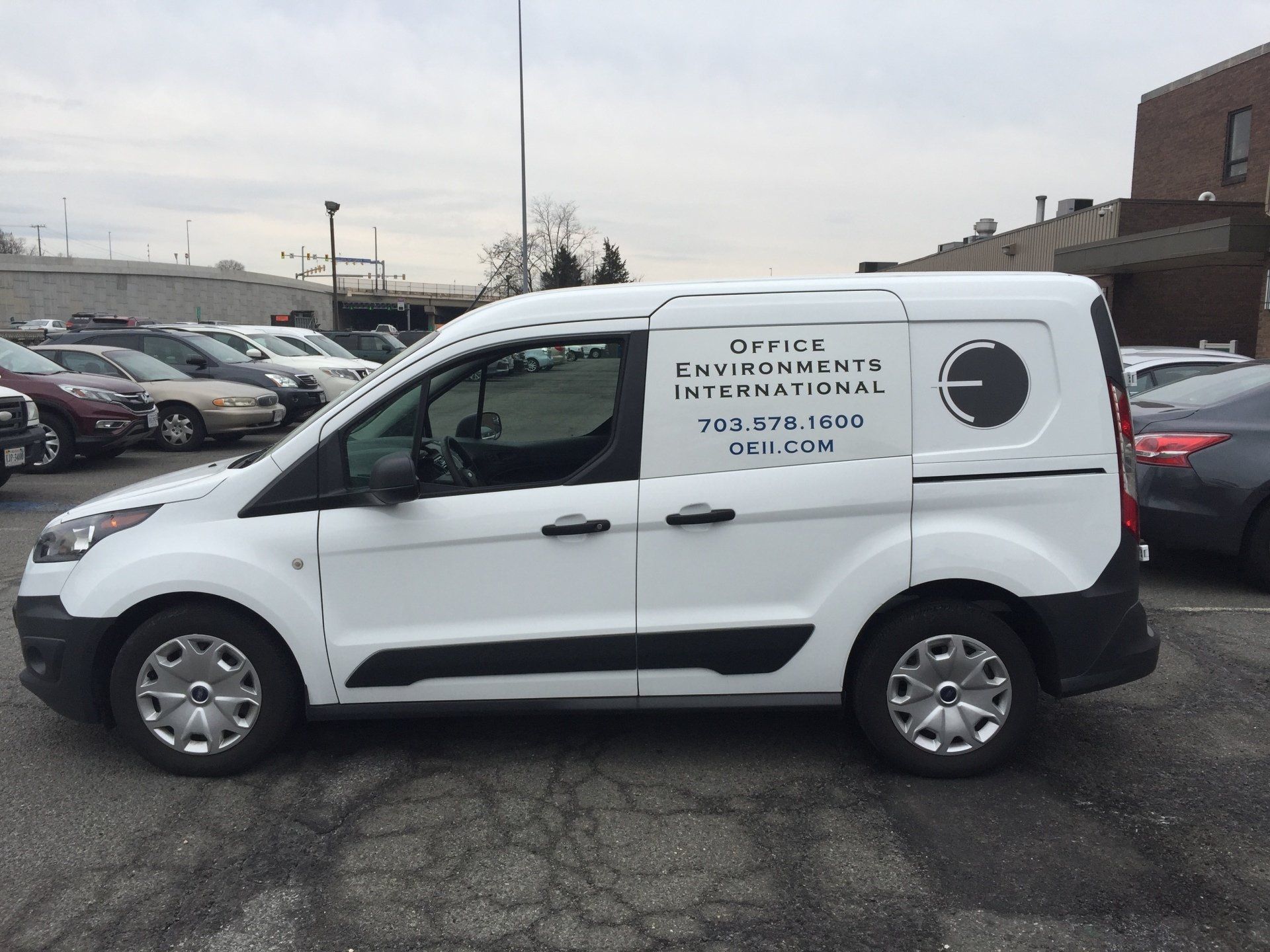 A white van with the word office on the side is parked in a parking lot