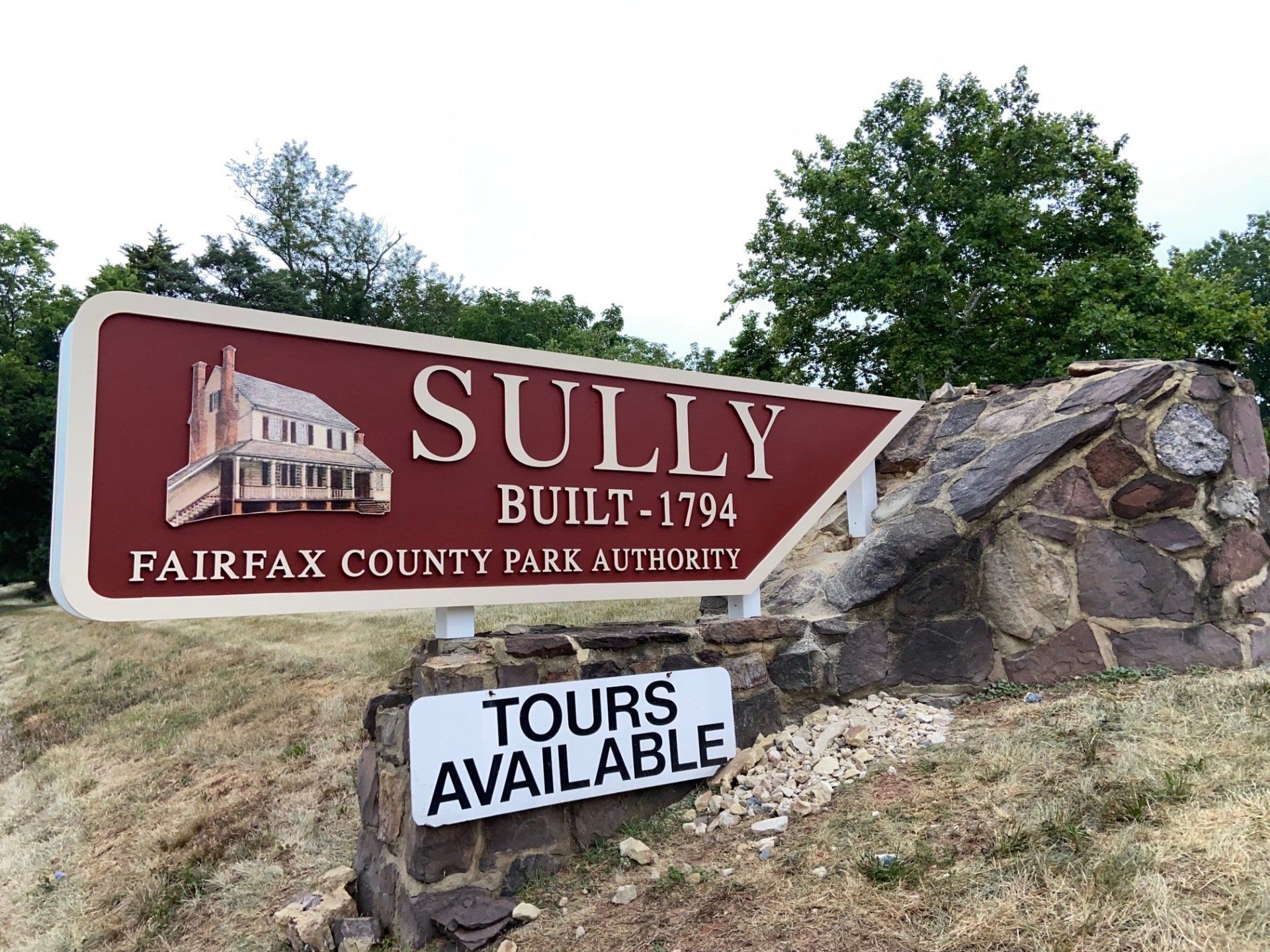 A sign for sully built in 1794 is on a stone wall.