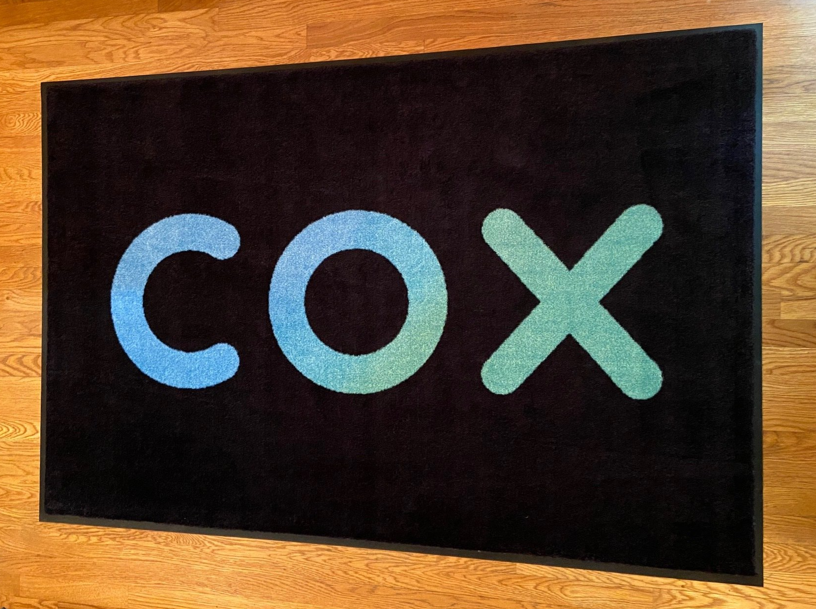 A black rug with the word cox on it