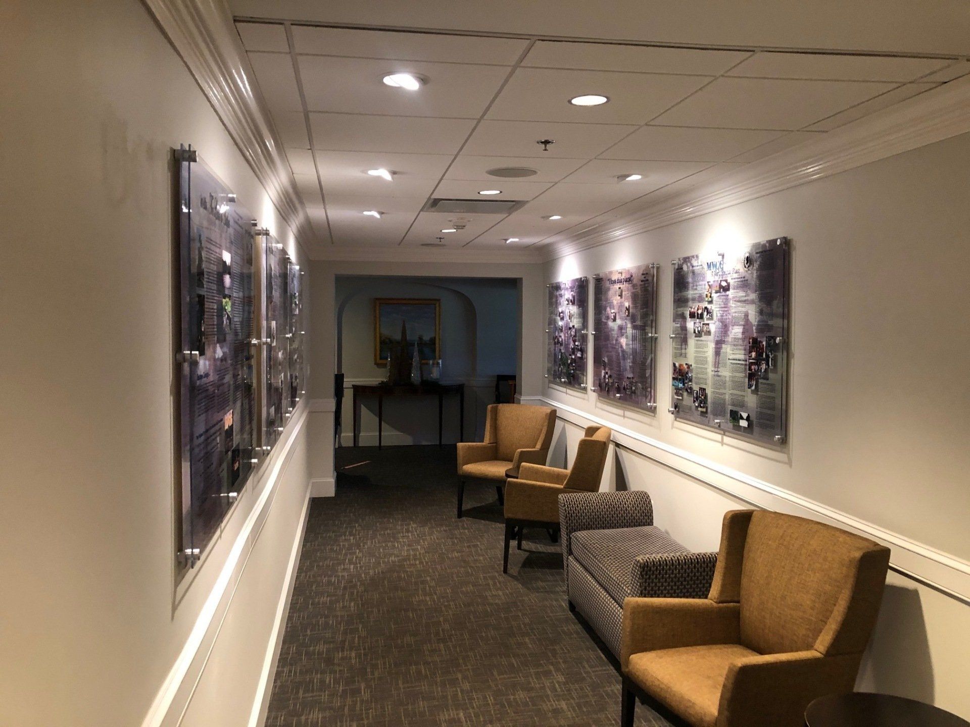 A hallway with chairs and paintings on the wall