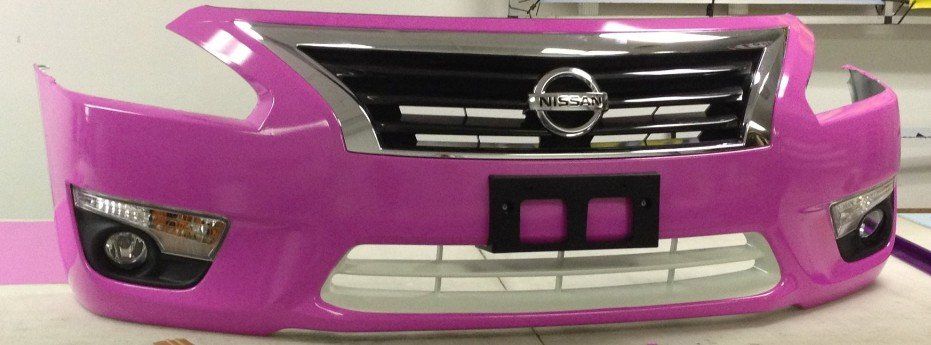 A pink nissan bumper is sitting on a table