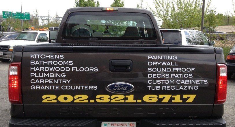 The back of a ford truck advertising various services