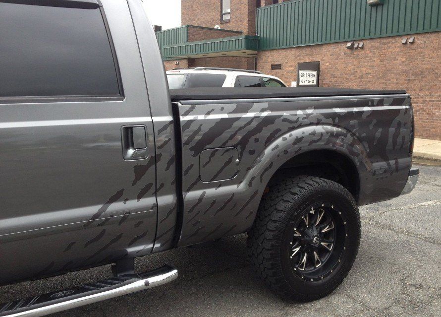 A gray truck is parked in front of a brick building