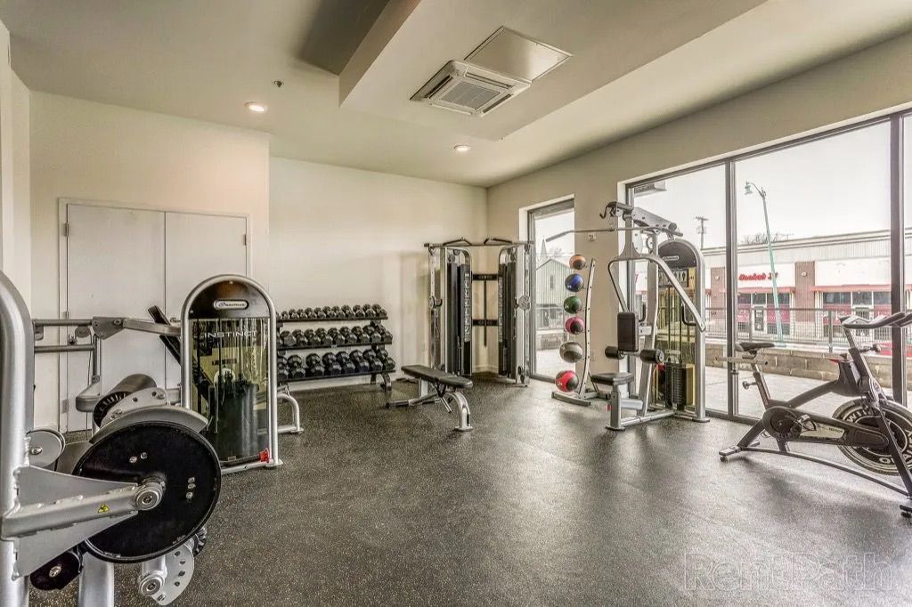 Clarksville, TN Pet-Friendly Student Apartments | Main608 | Fitness Center with Exercise Balls, Weight Training Machine, Stationary Bike, Elliptical Machines, Treadmills, and Expansive Windows.