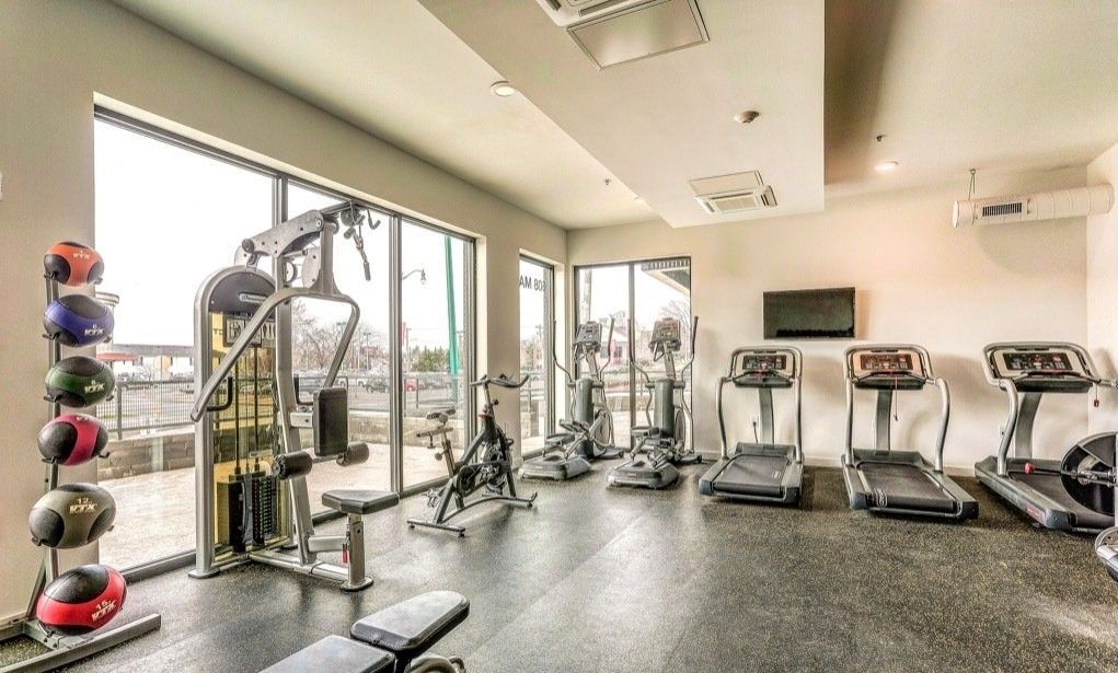 Clarksville, TN Pet-Friendly Student Apartments | Main608 | Fitness Center with Exercise Balls, Weight Training Machine, Stationary Bike, Elliptical Machines, Treadmills, and Expansive Windows.